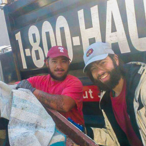  Image of two men wearing Temple branded hats in front of truck 