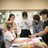 Teacher speaking with a group of students.