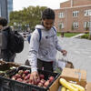 Student selects fresh produce at outdoor Share Fair for World Food Day