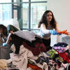 Students sorting donated clothing at Give + Go Green volunteer event.
