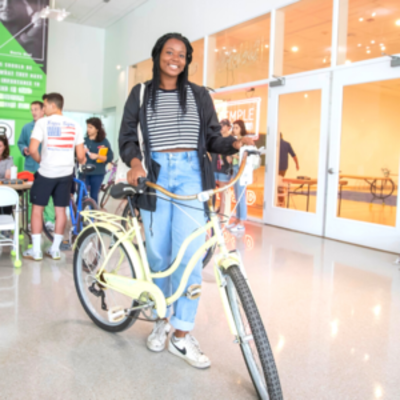 student stands with student at secondhand bike sale